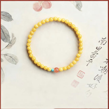 Yellow beaded bracelet on a decorative background with calligraphy