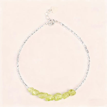 Necklace with green beads on a light pink background