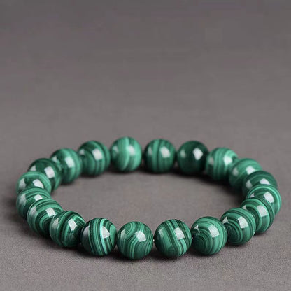 Green beaded bracelet on a gray background