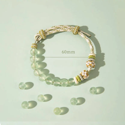Bracelet with green beads and gold accents on a light green background