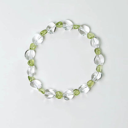 Bracelet with green and clear beads on a light gray background