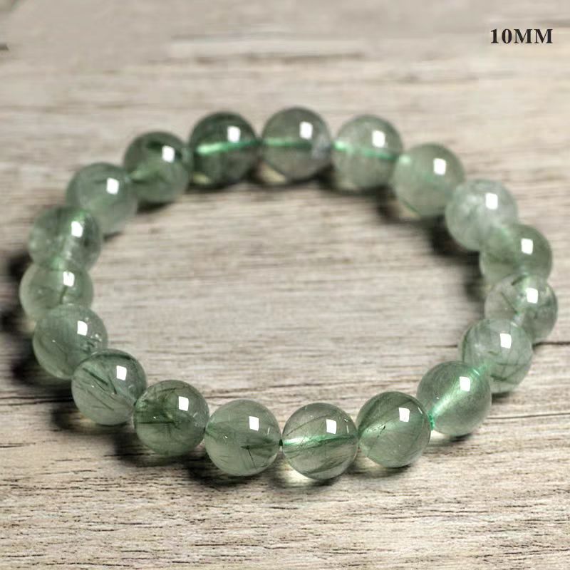Green beaded bracelet on a wooden surface with '10MM' text.