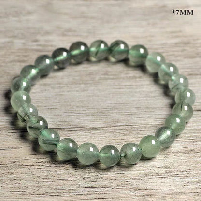 Green beaded bracelet on a wooden surface