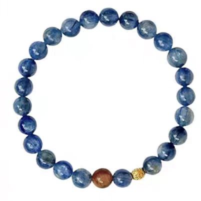 Blue beaded bracelet with a gold accent on a white background