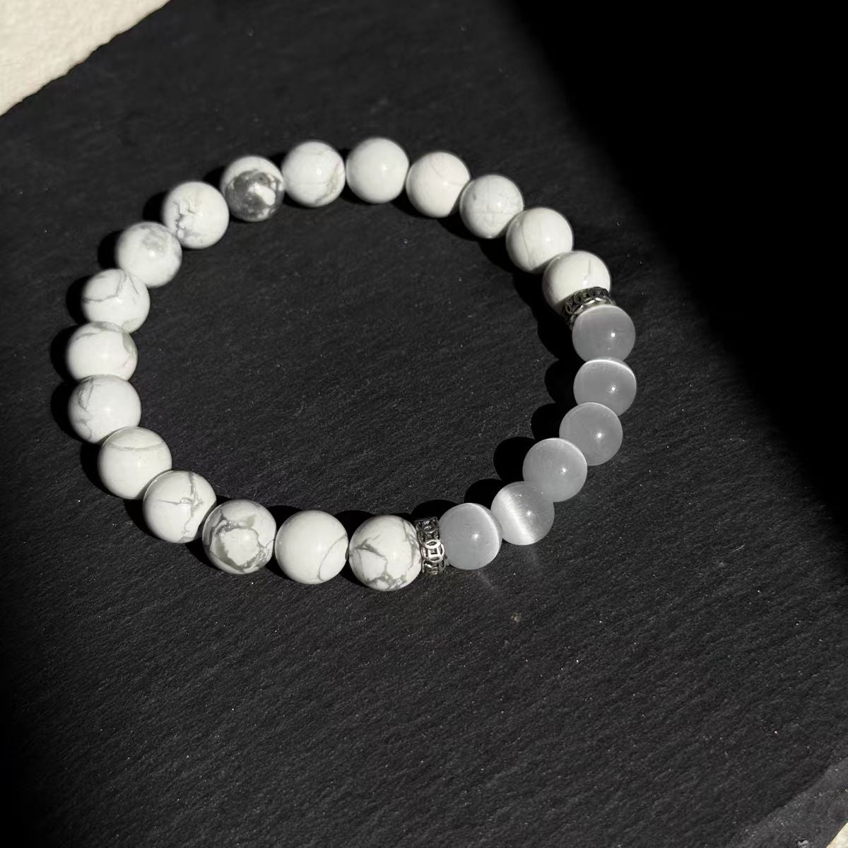 Beaded bracelet with silver accents on a dark surface