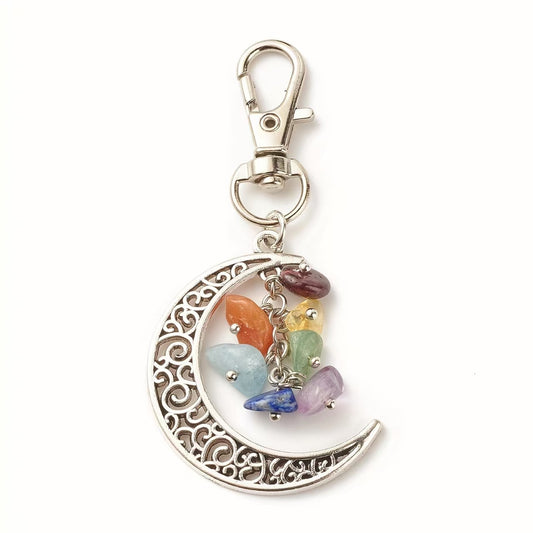 Silver crescent moon keychain with colorful stones on a white background