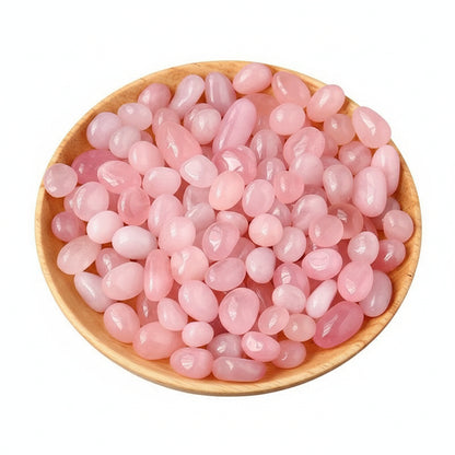 Pink crystal stones in a wooden bowl on a white background
