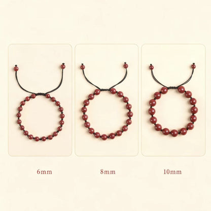Three red beaded bracelets of different sizes on a beige background