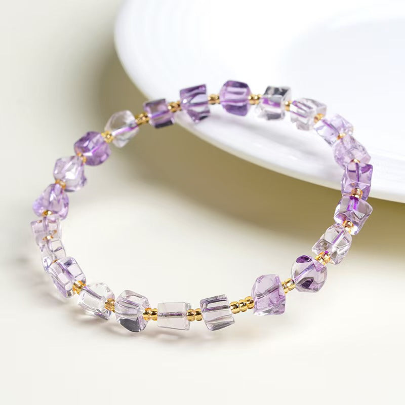 Beaded bracelet with purple and clear beads on a white background
