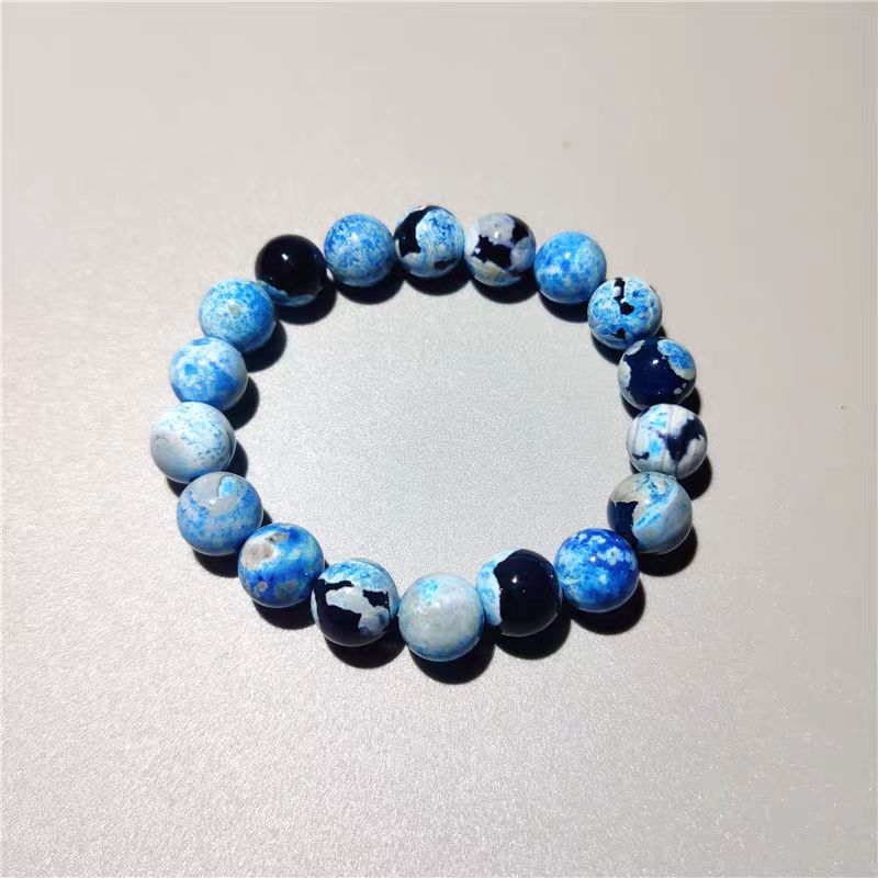 Beaded bracelet with blue and black marbled pattern on a light gray background